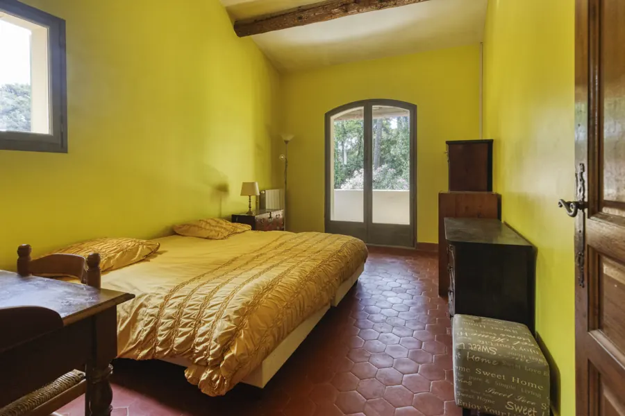 A bedroom looking onto greenery